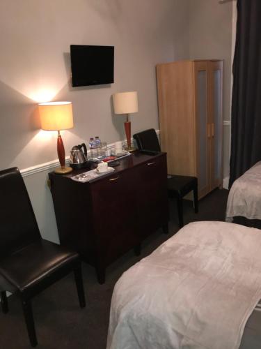 a hotel room with a desk and a bed at The Ocean Inn in Edinburgh