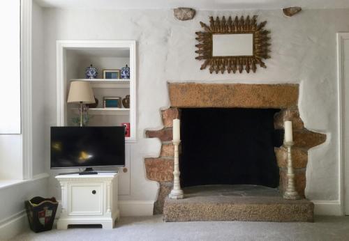 sala de estar con chimenea y TV en Fabulous Apartment in Historic House in St Aubin en Saint Aubin