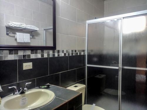 a bathroom with a shower and a sink and a toilet at Real Guanacaste in San Pedro Sula