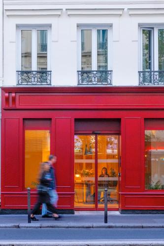a red store front with people walking in front of it at 9Hotel Bastille-Lyon in Paris