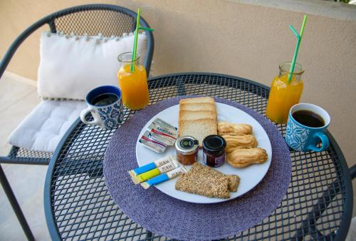 a plate of breakfast food on a table with drinks at Evangelos Apartments in Platanias
