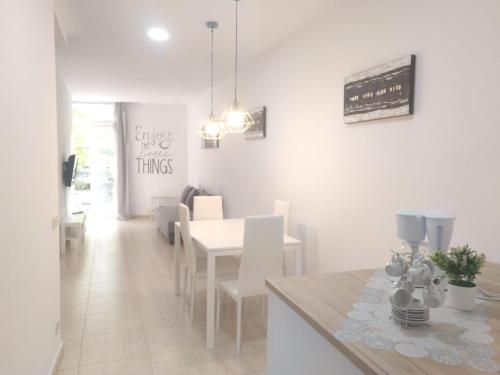 comedor con mesa blanca y sillas blancas en Mejor Apartamento en Plaza España con Parking Gratuito, en Barcelona
