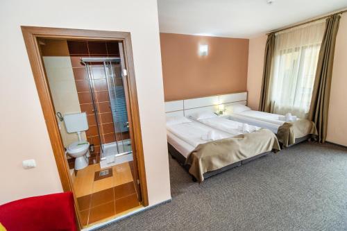 a hotel room with a large bed and a bathroom at Long Street Hotel in Braşov