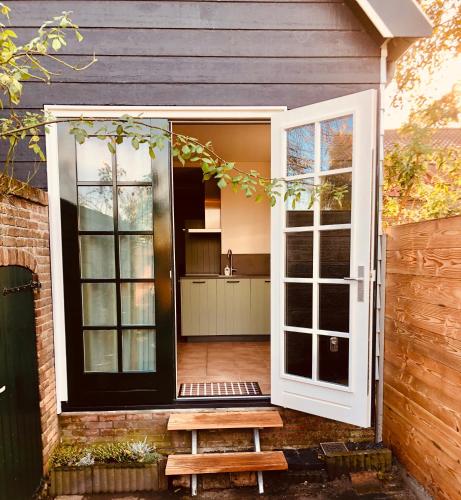 an open door of a house with a bench at het zwaluwnest in Koudekerke