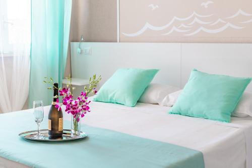 Una cama blanca con una mesa con flores. en La Smeralda - Boutique Rooms and Breakfast en Golfo Aranci