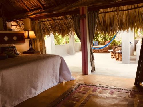 Un dormitorio con una cama y un patio con una hamaca. en Hacienda La Rusa, en Barra de Potosí