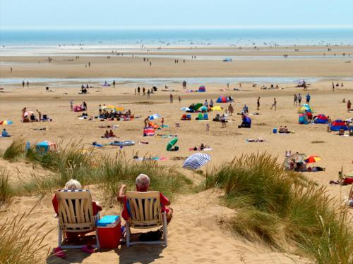two people sitting in chairs on a beach at River Lodge Platinum Plus Holiday Home with River Views, Free Wifi & Netflix in Camber