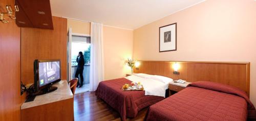 a hotel room with two beds and a flat screen tv at Hotel Dal Ponte in Bassano del Grappa