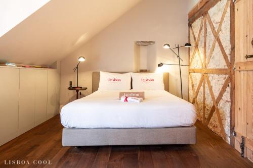 a bedroom with a white bed in a attic at Dare Lisbon House in Lisbon