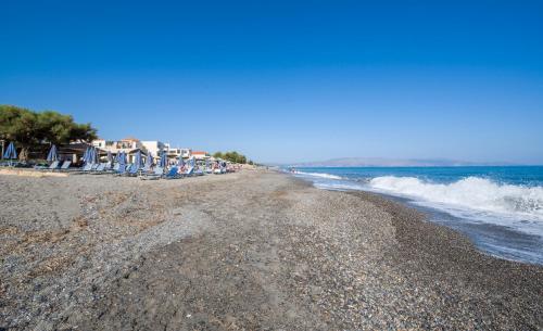 a beach with a group of chairs and the ocean at Evangelos Apartments in Platanias