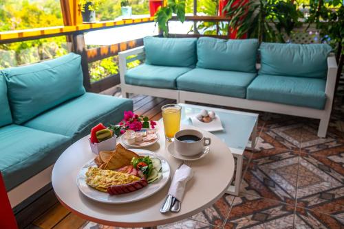 a breakfast table with a plate of food and a cup of coffee at Papaya Inn in Oranjestad