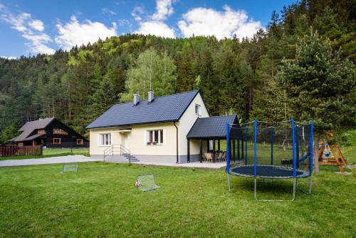 a playground in a yard with a house at Chata pod lesom Kvačany in Kvačany
