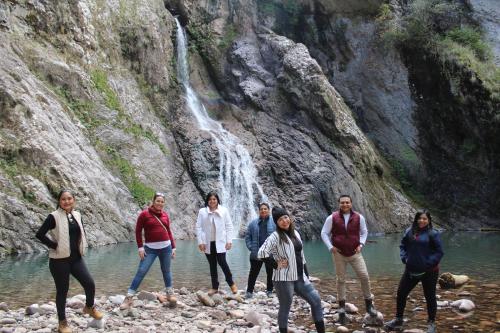 a group of people standing in front of a waterfall at Hotel Paraiso del Oso in Cerocahuí