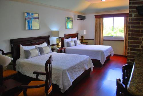 a hotel room with two beds and a window at Platino Hotel & Casino in Santiago de los Caballeros