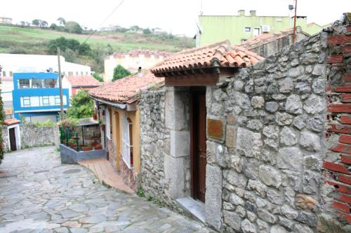 una antigua casa de piedra con un callejón de piedra en Pensión Argüelles, en Ribadesella
