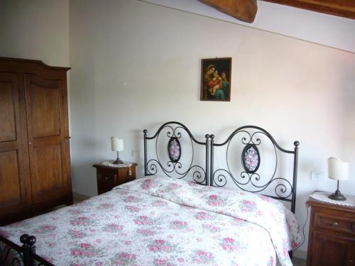a bedroom with a bed with a floral bedspread at Il Colle Rigomagno in Rigomagno