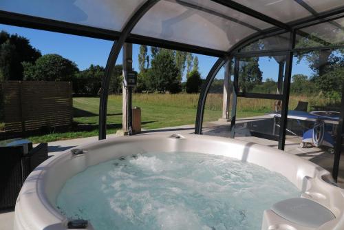a jacuzzi tub with a view of a yard at Les Gîtes de Douar Bouillon in La Chapelle-Neuve