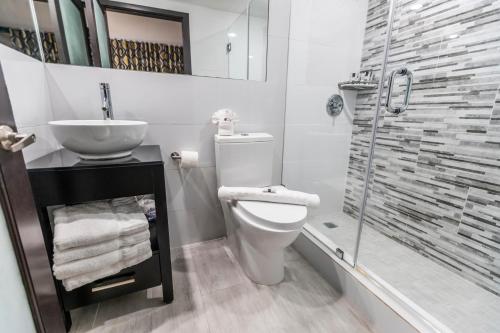 uma casa de banho com um WC, um lavatório e um chuveiro em Metropole Suites South Beach em Miami Beach