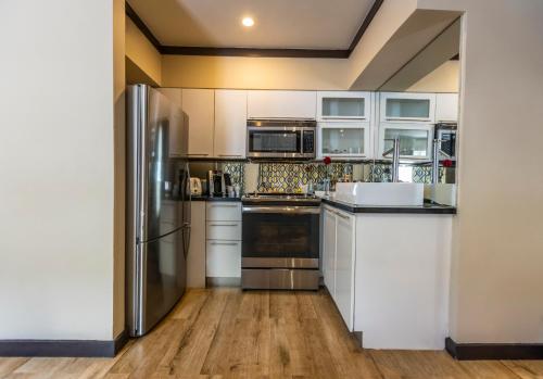 a kitchen with a refrigerator, stove, sink and dishwasher at Metropole Suites South Beach in Miami Beach