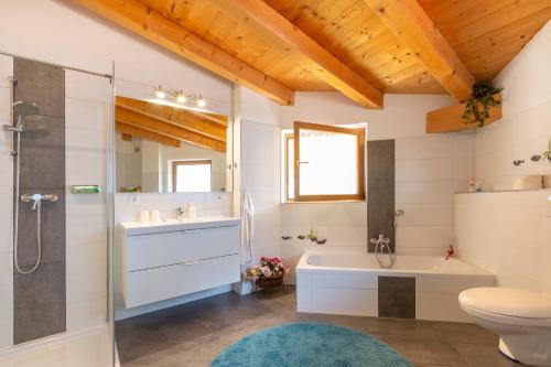 a bathroom with a tub and a toilet and a sink at Haus Sophia - Erholung mit Berg und Talblick in Oberperfuss