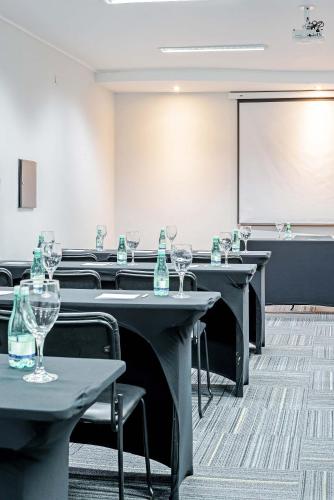 a room with tables and chairs and a projection screen at Rede Andrade Braz in Curitiba