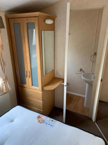 a small bathroom with a toilet and a sink at Chapel Caravans PS12A in Chapel Saint Leonards