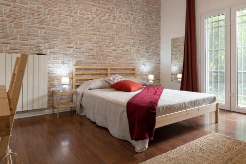 ピサにあるVilla Noemi Bed&Breakfastのレンガの壁、ベッド付きのベッドルーム1室