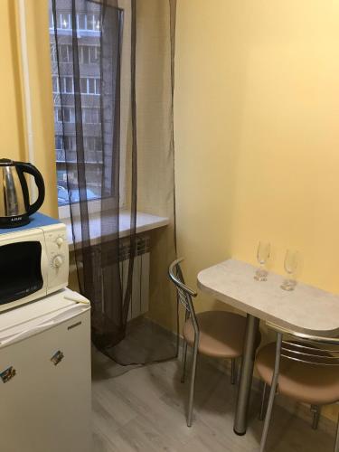 una pequeña cocina con mesa y 2 copas de vino en Киев сдам посуточно ул Доброхотова 28 Daily rent Kyiv st Dobrokhotova 28 en Kiev