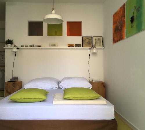 a bed with two green pillows in a room at Mosel - River - Quartier 31 in Lieser