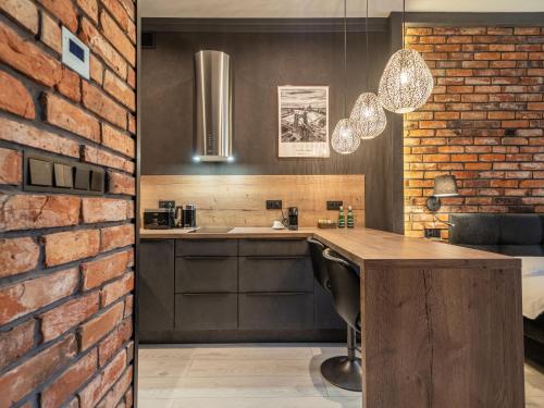 a kitchen with a brick wall and a wooden table at Loft House Premium Apartments in Wrocław