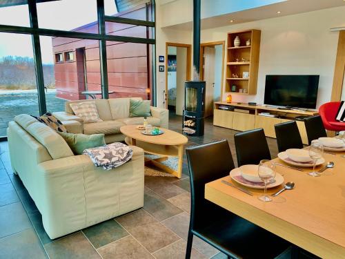 a living room with a couch and tables and a tv at Nes in Bifrost