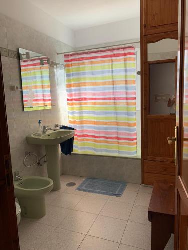 a bathroom with a sink and a toilet and a shower curtain at Casitas Rosheli in Los Llanos de Aridane
