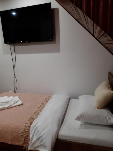 a bedroom with a bed with a flat screen tv on the wall at Maison ALANA in Divčibare