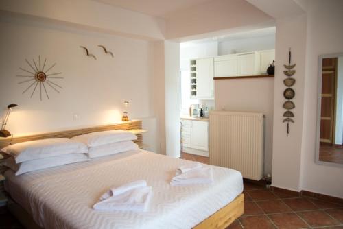 a bedroom with a white bed with towels on it at Olea Escape Villa in an Olive Estate in Gythio