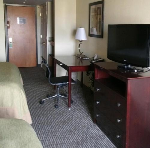 a hotel room with a desk and a television at Wingate by Wyndham Dayton - Fairborn in Fairborn