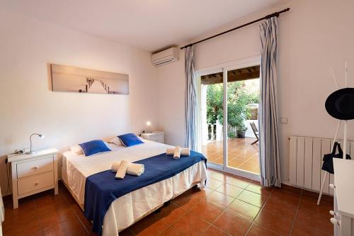 a bedroom with a bed and a sliding glass door at Villa Mercedes in Cala Llonga