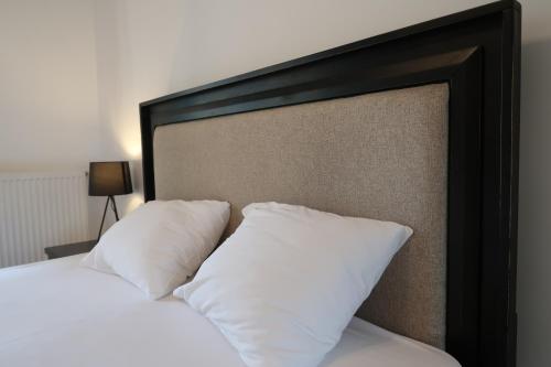 a bed with white pillows in a bedroom at Orange Onix Apartaments in Bucharest