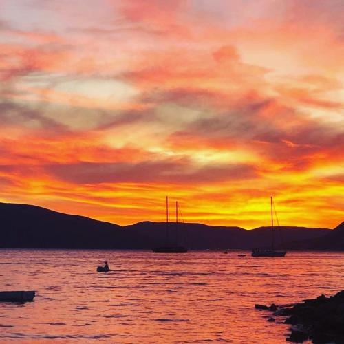 a sunset over a large body of water with boats at Tondo in Tivat