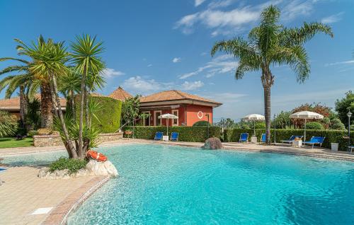 uma piscina com palmeiras e uma casa em Residence Villa Rosi em Laureana Cilento