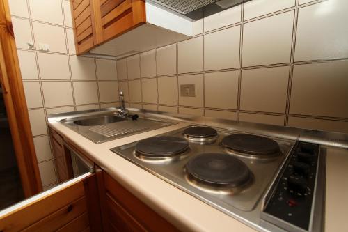 a kitchen with a stove top with a sink at Residence Raethia tra Bormio e Livigno in Valdidentro