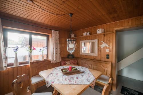 ein Esszimmer mit einem Tisch und einem Fenster in der Unterkunft Chalet am Hasensprung in Berchtesgaden