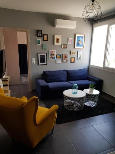 ein Wohnzimmer mit einem blauen Sofa und einem Tisch in der Unterkunft City Life Apartments #1 in Ioannina
