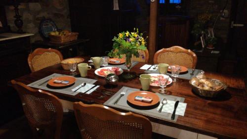 una mesa de madera con platos y utensilios. en Albergue Camino y Leyenda, en Trabadelo