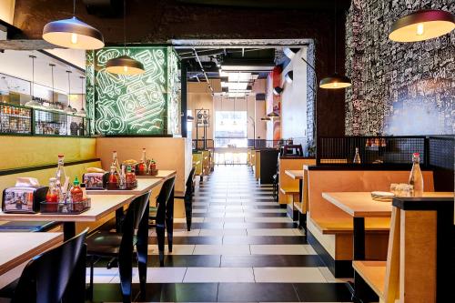 un restaurant avec des tables et des chaises et un mur vert dans l'établissement Kixby, à New York