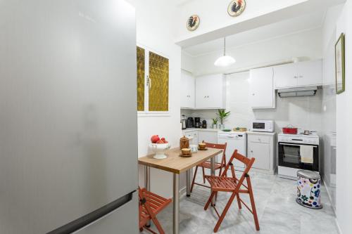 cocina con mesa de madera y 2 sillas en A Short Walk to Syntagma and Plaka by Athenian Homes en Atenas