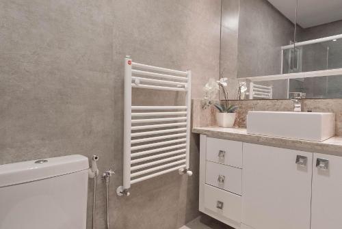 ein weißes Badezimmer mit Waschbecken und Toilette in der Unterkunft Via Florida Luxo II - 303 in Gramado