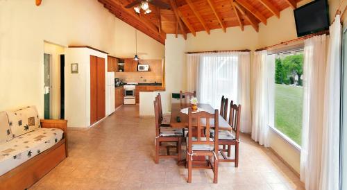 una cucina e una sala da pranzo con tavolo e sedie di Solar Encantado Cabañas & Chalet a Villa General Belgrano