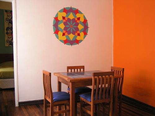 a dining room table with two chairs and a clock at Casa Violeta Limón in Valparaíso