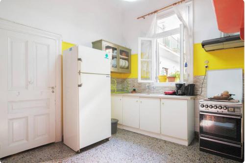 een keuken met een witte koelkast en een fornuis bij Neoclassical house in the center of Athens in Athene