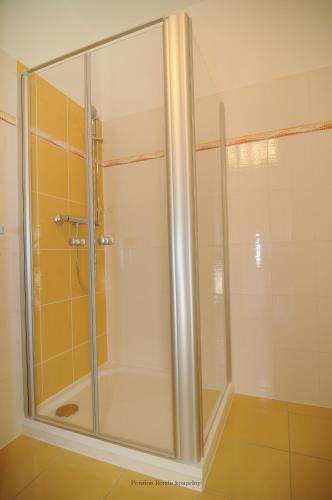 a shower with a glass door in a bathroom at Penzion Rondo in Bystřice pod Hostýnem